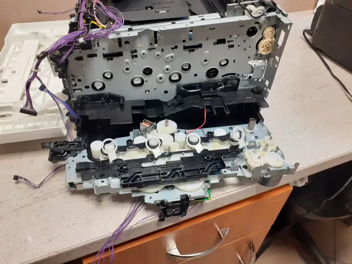 Drukarka laserowa rozebrana do naprawy mechanizmu podawania papieru